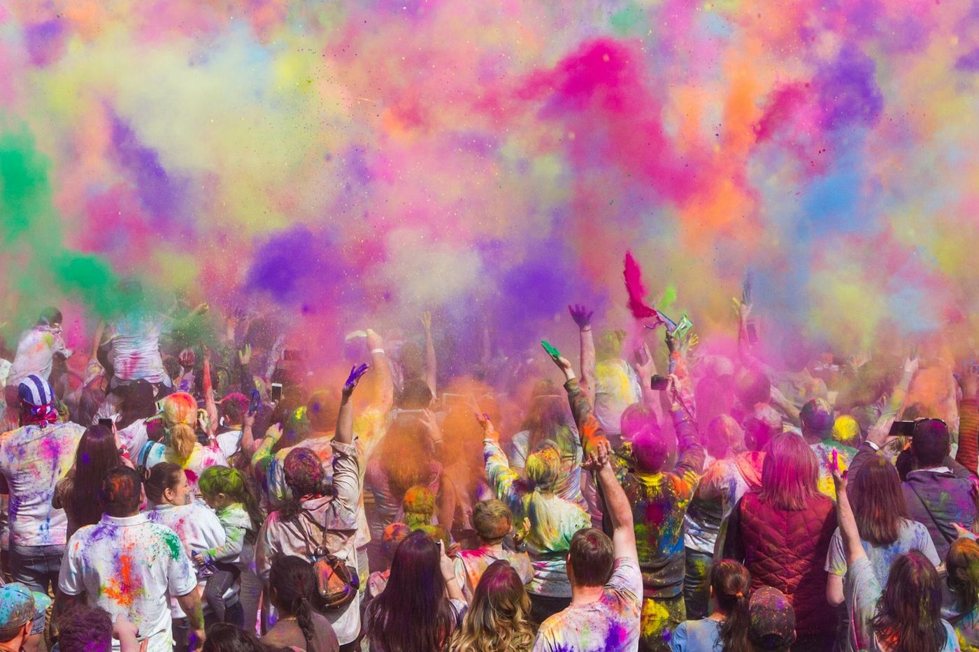 A crowd celebrating Holi with colour